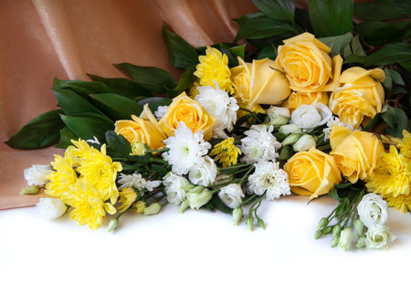 Beautiful large lush elegant fresh orange color flowerheads with vivid green leaves isolated on light backdrop. View close-up with space for textの写真素材