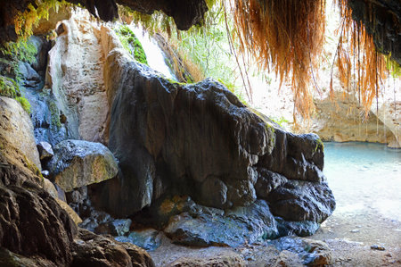Middle East Jewish scenic inside view from deep cavern. Pure brook flows in dark gorge Ein Gedi, in Judean desert on shore of Dead Sea. Place where judaic warrior David hid from King Saul in Palestineの写真素材