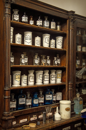 Museum Past of Physic Preparation. Kiev, Ukraine, 2017. Fluid in phial, powder in cap, poison in vial, ointment, herb elixir, flask set with text on label. Interior of obsolete brown wood storage caseの写真素材