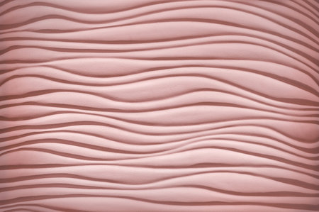 Luxury art template in form of sandy seaside shore dune bend shape in plain artistic style with soft shadow. Pastel rose color artistic gesso emboss build fond design. Closeup view with space for textの写真素材