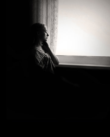 Pious orthodox lone pure worry pretty adult light white lady sit ask wish Lord Jesus Christ. Sin purity stress teen soul grace think life concept copyspace. Text space on dark black home room backdropの写真素材