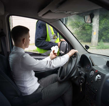 Adult rich male guy sit open show wait take help duty look travel card urban Europe city street old dark text space. Young human hold arrest catch violate law fraud proof order rent deal pay job buyの写真素材