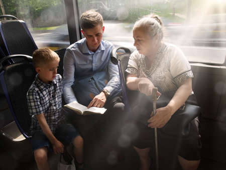 Young adult male guy father teach kid son help sit seat hand hold look old age female lady. Ask give...