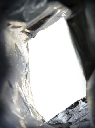 Close up bottom upward detail macro big large blank light gold plastic cold protect wrap tinfoil text space. Retro small pouch sack golden fried tasty salty sweet spicy idea border banner designの写真素材