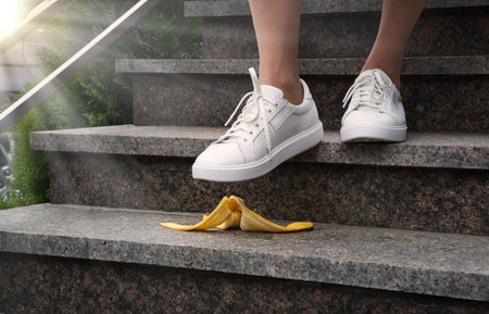 Adult young male guy worker under food fruit skin fit sole hurry urban town city work house move forward idea concept. Closeup view boy jogger office trap job risky fault outdoor travel risk error funの写真素材