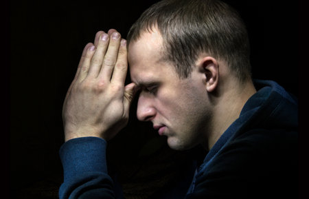 Dramatic orthodox evangelical baptist pious lonely stress mourn young white guy kneeling for ask implore wish upwards Jesus Christ. Modern think concept copyspace with space for text on dark backdropの写真素材
