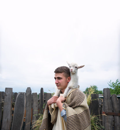 Old retro Arabian rural cute white young breed boy guy divine worker find small cute baby cattle herd pet. Middle east Asian Arab catholic believe Hebrew cloth Jew servant nomad pray love hope historyの写真素材