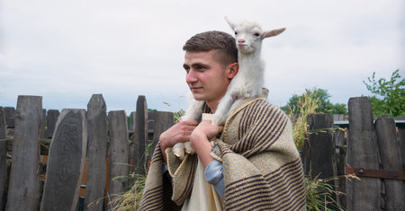 Old retro Arabian rural cute white young breed boy guy divine worker find small cute baby cattle herd pet. Middle east Asian Arab cloth Jew servant nomad pray hope historyの写真素材