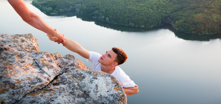 Close up 2 young alpinist job leader guy unity arm care try rise trust hope lake sea river. Hang woman ask aid life fall crisis raise effort win reach hill top peak overcom abyss gap sky sunの写真素材
