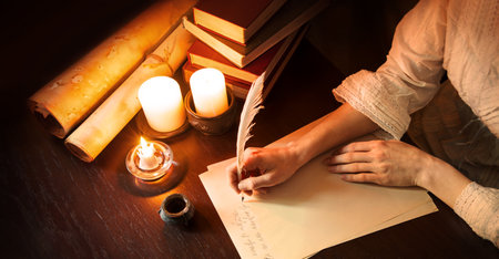 Close up top view ancient law mail notice page read space. Closeup age male arm hold nib inkwell scribe draw art diary teach notepad card author human man boy dark black wood desk tableの写真素材