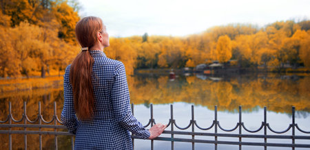 Young adult lady feel worry mental grief anxiety cry mood stand spring urban city town shore even sky view text space. Lost love pretty dress young teen upset fall old tree calm morn peace lifeの写真素材