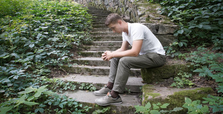 Young teen age mental fail despair grief boy feel hope travel seat retro vintag town brick ruin bush text space Tired lost human guy wait cry old rustic village hill home house wallの写真素材