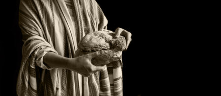 Tasty fresh hot white round barley grain bun crust help work hungry girl kid child. Closeup old male arm faith feed warm crusty rye diet cuisine retro dark black home text spaceの写真素材