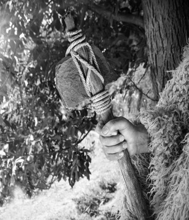 Closeup past retro primev archaic neolith era native culture strong craft mallet worker arm forest...
