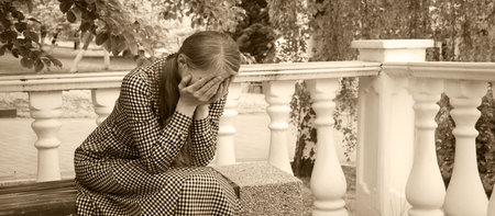 Young adult age dress lady feel guilty shame mourn struggle loss frown grief mood old seat relax rest gloomy spring tree text space. Sullen misery guilt afraid lost love hand hide face dream god faithの写真素材