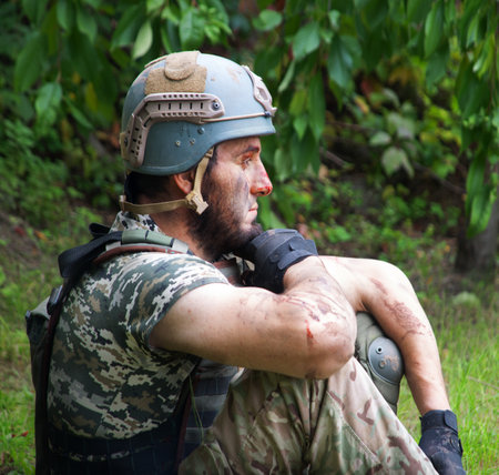 Alone tired male guy sit rest hand protect look hope pain post danger dark forest tree bush text space. Lone worry human cry feel upset lost medic hero god faith worship conceptの写真素材