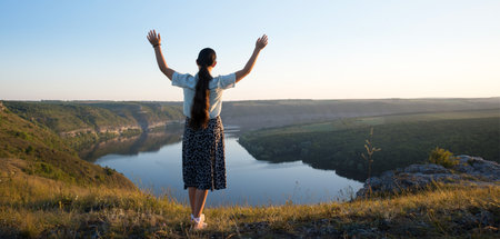 Young alone teen lady stand rock ask beg help win life light sun text space Lone mental forgiv devot faith free arm up bless calm sunny heaven hill field garden parkの写真素材