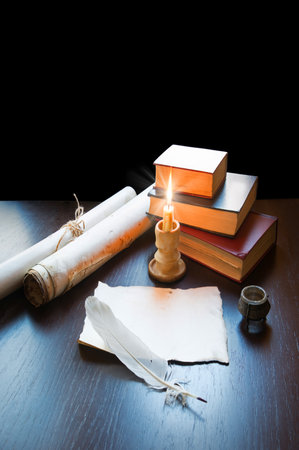 Grunge age worn psalm teach pray open sacred torah law ink quill pen paper page dark black night desk table. New culture god Jesus Christ gospel prayer literary warm fire flame oil pot art still lifeの写真素材