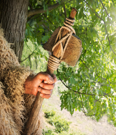 Closeup past retro primev archaic neolith era native culture strong craft mallet worker arm forest...