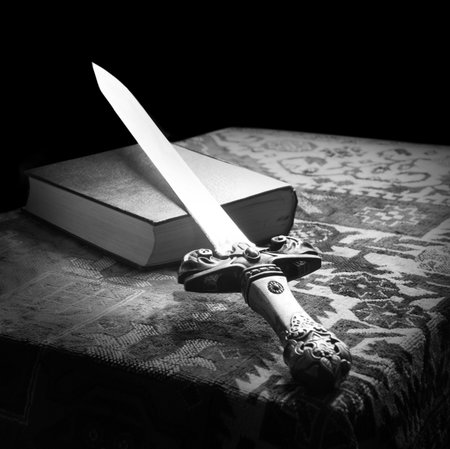 Closeap King age army read light paper page learn believe bless pray hebrew law steel iron metal sharp dark black table text space. New culture sacred spirit prayer art gold arm worship life sign iconの写真素材