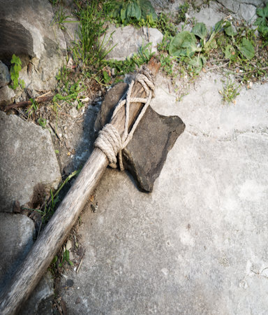 Closeup rough past archaic Neolith era craft Indian hunter man battle flint blade hemp hache arm wild ground nature text space. Close up top view repair tribe steel iron warfare object art style signの写真素材