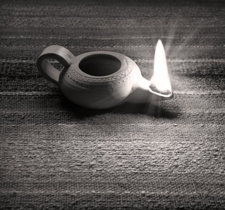 Closeup classic rural art middle arabian shiny kerosene jug jar vase burner wick blow table text space. Close up hand magic arab rustic past age design decor styleの写真素材