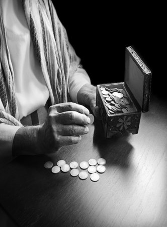 Senior person opening a bag and counting coins.