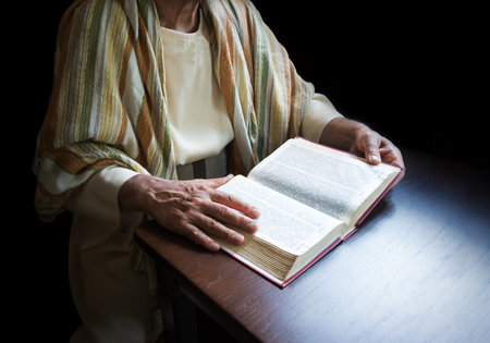 Closeup past elder age jew girl trust church school biblic gospel word israel judaism torah law symbol concept. Devote adult jewish guy pastor hold arm preach dark black wood desk spaceの写真素材