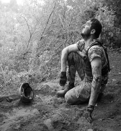 Alone tired lost USA patriot navy protect guy face kneal rest hand look sky hope pain grief post trouble danger forest tree text space. Lone worry human cry feel upset medic hero ask god faith worshipの写真素材