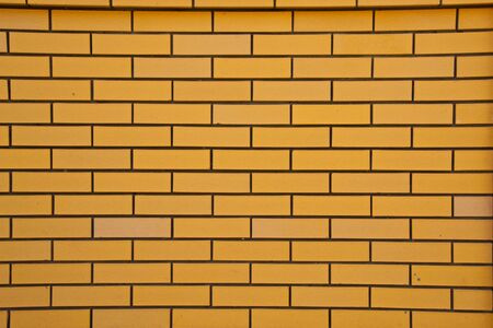 Yellow brick wall. Yellow color photo of a brick close up on the wallの写真素材
