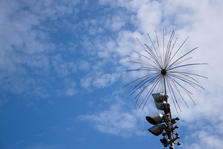 Iron electro-steel against a blue sky and white clouds with an art object and searchlights, electric...
