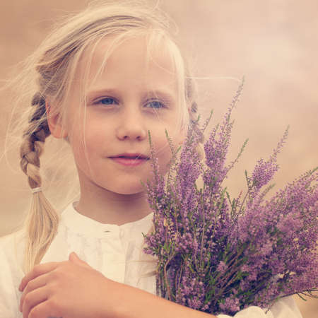 Carefree young girl with flowers outdoorsの写真素材