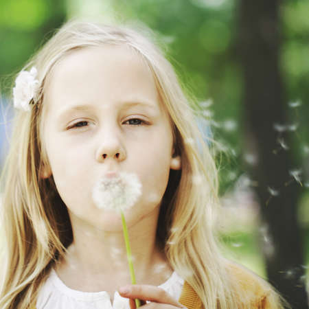 Cute child and dandelion on greenery backgroundの写真素材