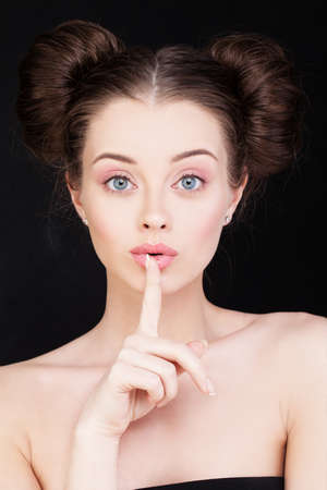 Woman Holding her Finger to her Lips in a Gesture for Silenceの写真素材