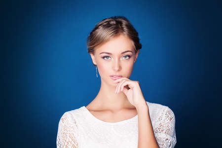 Young Pensive Woman on Blue Backgroundの写真素材