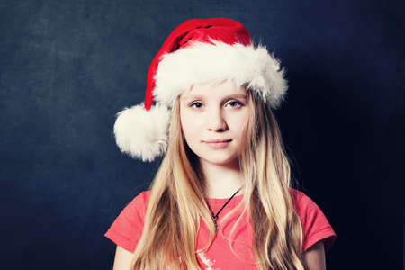 Christmas Teen Girl in Santa Hat on Dark Background