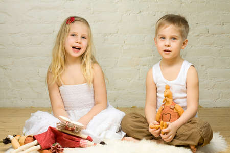 Smiling blond children play with toysの写真素材