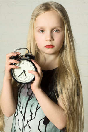 Beautiful girl holding alarm clockの写真素材