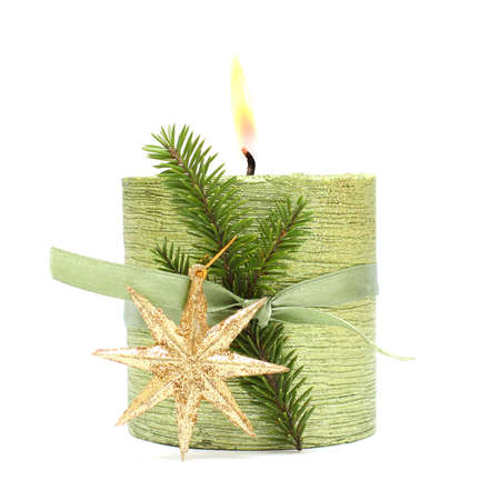 Christmas candle, green ribbon and gold New Year star isolated on whiteの写真素材