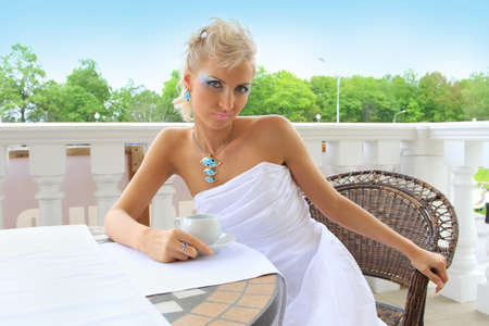 Stylish fashion model sitting in a restaurant outdoorsの写真素材