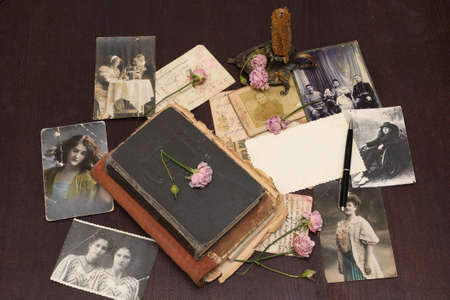 Vintage background with old books, postcards, photographs and flowers