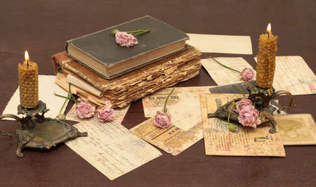 Vintage background with old books, postcards, candles and flowersの写真素材