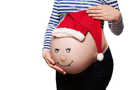 Pregnant Woman. Baby Bump with Santa Hat Isolated on Whiteの写真素材