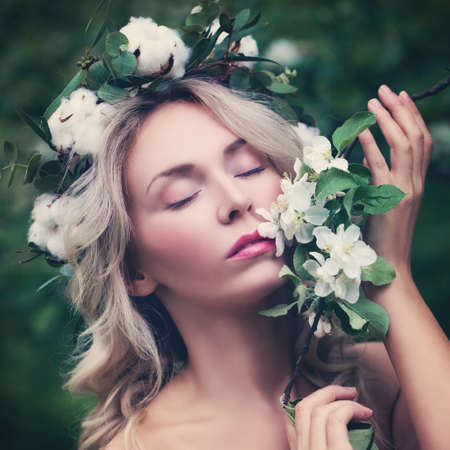 Relaxing Woman with Flowers Outdoors. Beautiful Woman with White Apple Flowersの写真素材