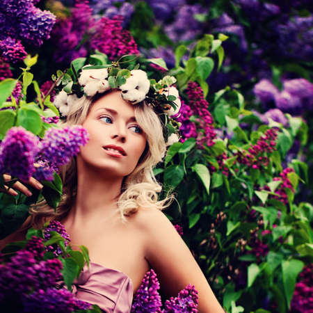 Young Blonde Woman with Flowers in the Spring Gardenの写真素材