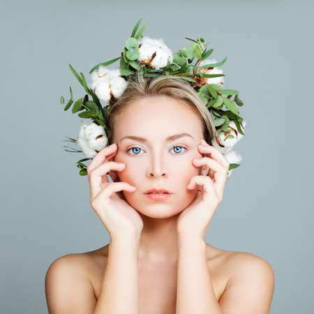 Perfect Girl in a Wreath of Green Leaves and Cotton Flowers. Spa Woman with Healthy Skinの写真素材