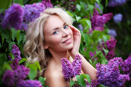 Spa Model Woman with Healthy Skin and Blonde Hair on Flowers Background. Spring Beauty, Facial Treatment and Cosmetology Conceptの写真素材