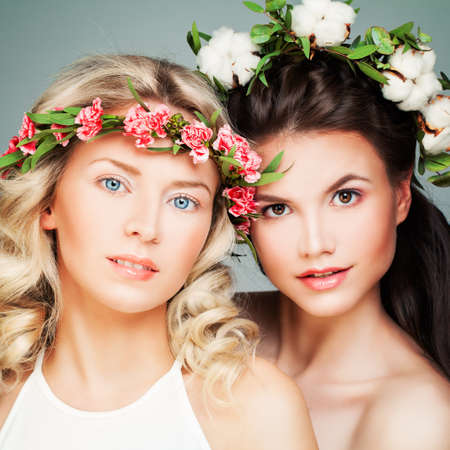 Beautiful Blonde and Brunette Models. Fashion Beauty Portrait of Nice Women with Flowersの写真素材