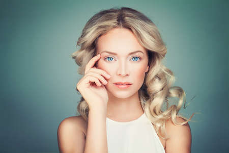 Friendly Blonde Woman Fashion Model with Curly Hair and Natural Makeupの写真素材
