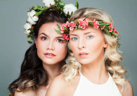 Beauty Portrait of Brunette and Blonde Women Fashion Models in Flowers Wreathの写真素材